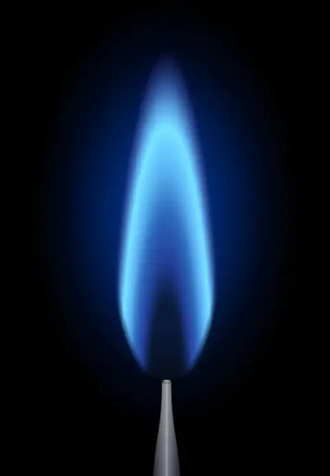 A closeup of the blue flame called a pilot light in a gas burning heating system.