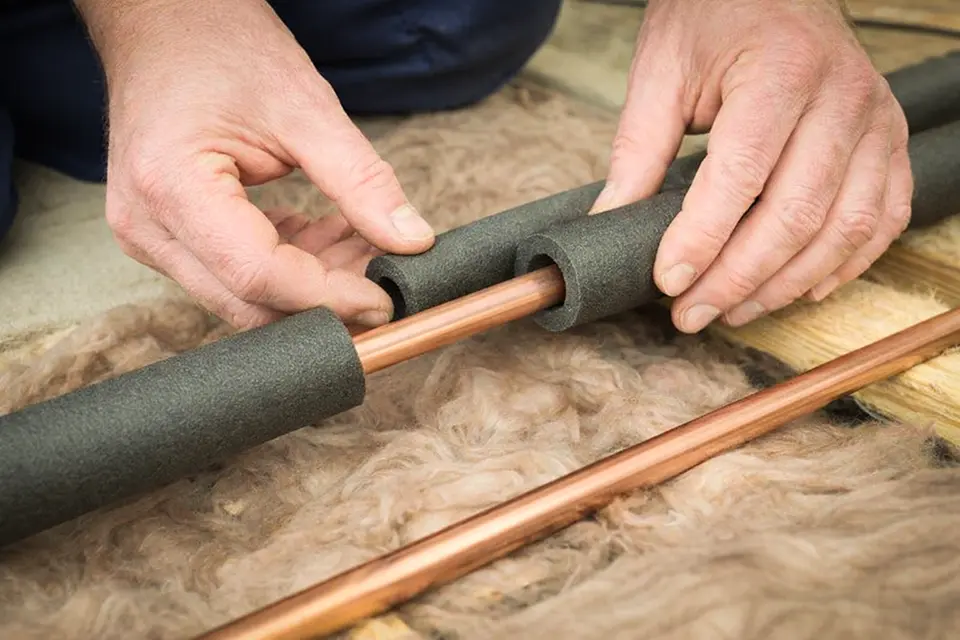 Putting insulation on pipes to avoid freezing and bursting.
